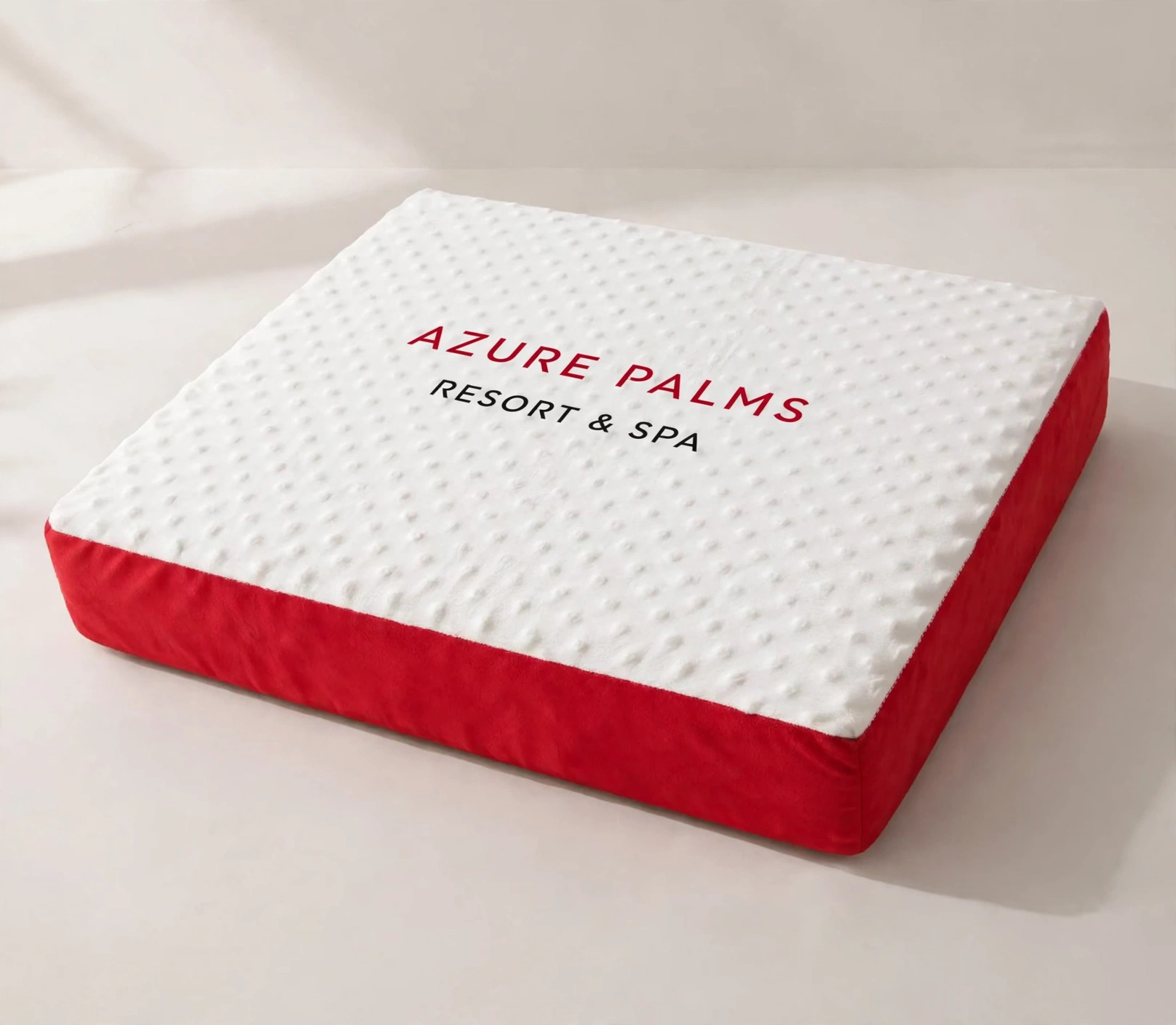 Illustrative sample: large dog bed with white quilted top, red side panels, and Azure Palms Resort and Spa branding.